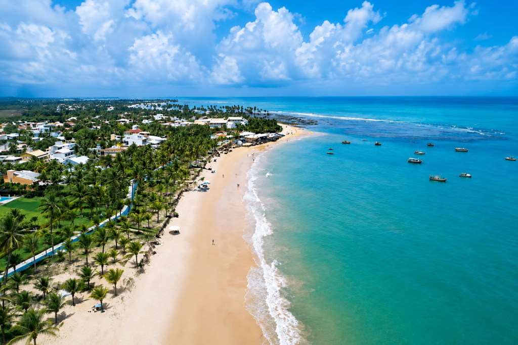 Vista aérea da Praia do Forte em Aracaju, Sergipe, com mar azul-turquesa, faixa de areia dourada, coqueiros e embarcações, um dos principais destinos turísticos para passeios no litoral sergipano.