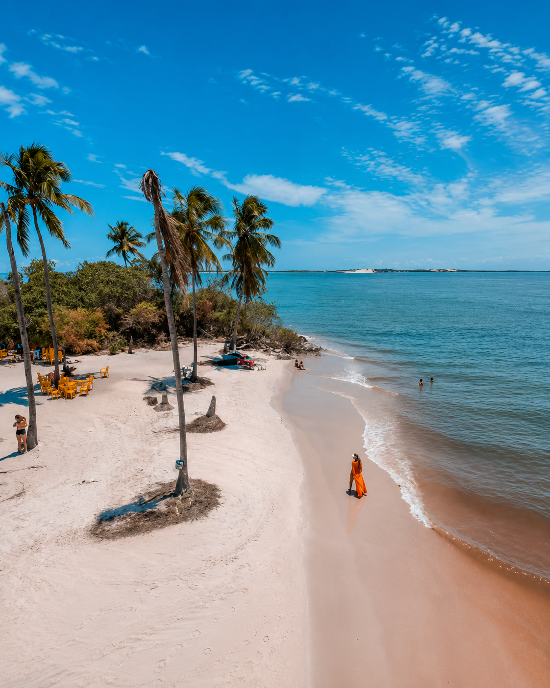 Vista panorâmica da Praia do Saco, em Sergipe, com areia branca, coqueiros, mar azul-esverdeado e paisagem paradisíaca, um dos passeios mais procurados por turistas que visitam Aracaju.